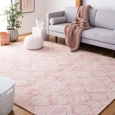 a living room with a gray couch and pink rug