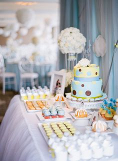 a table topped with lots of cakes and cupcakes