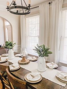 the dining room table is set with plates and place settings for two people to eat