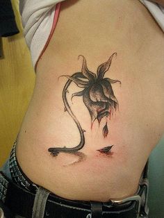 a woman's stomach with a tattoo on the side and an insect crawling out of it