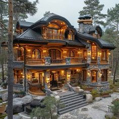 a large house with lots of windows and lights on it's sides in the woods