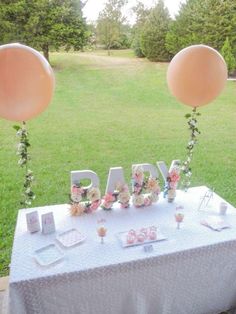 a baby shower table with balloons and flowers