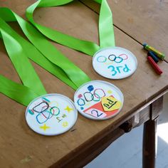 three badges with numbers on them are sitting on a table next to green streamers