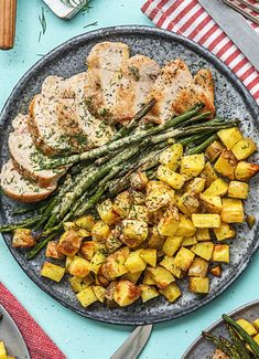 a plate with chicken, potatoes and asparagus on it