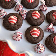 chocolate cookies decorated with candy canes and candies on a white platter, ready to be eaten