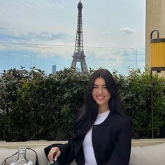 a woman sitting on a couch in front of the eiffel tower