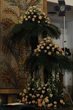 a large floral arrangement on display in front of a painting