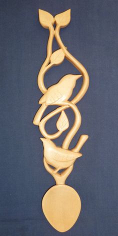 a wooden sculpture with two birds on it's sides and a heart in the middle