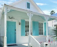 a small white house with blue shutters