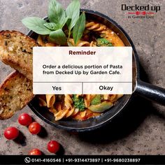 a pan filled with pasta and vegetables next to some slices of bread on the table