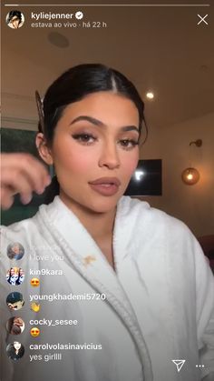 the woman is getting her hair done and looking at the camera while wearing a robe