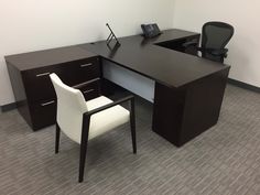 an office desk with two chairs next to it