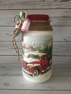 a mason jar with a red truck painted on it and a ribbon tied around the top