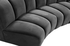 an upholstered black velvet sofa with curved back and armrests, viewed from the front