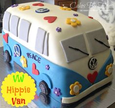 a cake shaped like a bus with peace signs on the side and flowers all over it