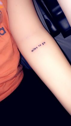 a woman with a tattoo on her arm that reads miles to go and the words