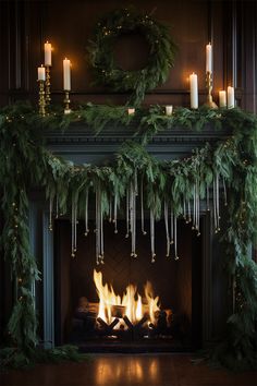 a fireplace decorated with christmas garland and candles