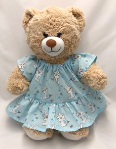 a brown teddy bear wearing a blue dress