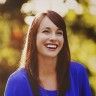 a woman with long hair smiling for the camera