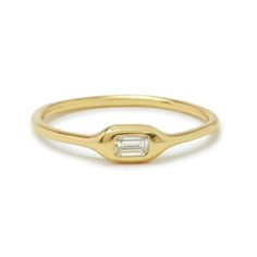 a gold ring with a baguette cut diamond in the middle, on a white background