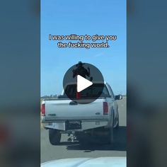 a white truck driving down a road next to a sky background