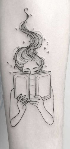 a woman reading a book with her hair blowing in the wind tattoo on the leg