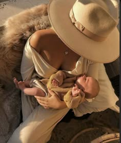 a woman in a hat holding a baby