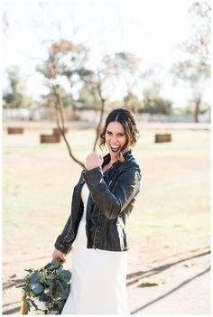 a woman in a white dress and black leather jacket