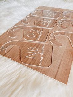 a wooden cutting board with white writing on it and hearts in the shape of letters