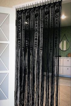 a black curtain with fringes hanging from it's side in front of a mirror