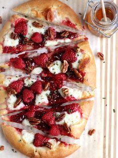 a pizza with raspberries, cream cheese and pecans