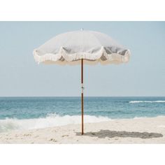 an umbrella sitting on top of a sandy beach