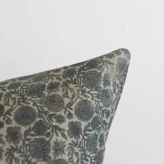 a close up of a pillow on a white background with black and grey flowers in the middle