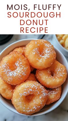 a bowl filled with sugar covered doughnuts on top of a table