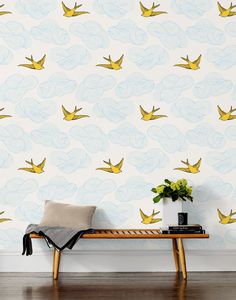 a wooden bench sitting in front of a wall with yellow birds on it's side