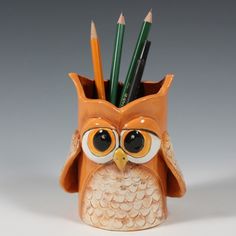 an owl shaped pen holder with pencils sticking out of it