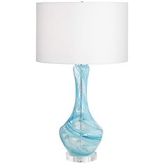 a blue glass table lamp with a white shade