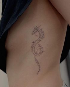 a woman's stomach with a tattoo design on the side, showing her lower back