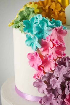 a white cake with multi colored flowers on top