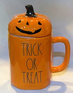 a ceramic pumpkin mug with a trick or treat written on it