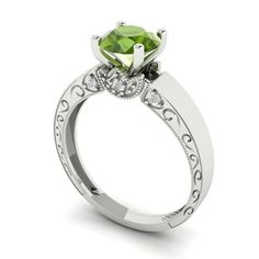 a white gold engagement ring with a green diamond