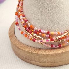 Delicate handmade stretch elastic bracelet created with dainty seed beads in summer colors of pink, orange, and accents of gold.  Strung with a 42-inch sturdy stretch elastic beading cord, bracelet wraps around 5 to 6 times on wrist sizes 6 to 8 inches.  .  (Please note, this is a single strand bracelet that you wrap around your wrist.) Stackable wrap bracelet can also be worn as a necklace. Purchase for yourself or as a gift. Bohemian Stretch Bracelet With Colorful Beads, Bohemian Orange Stretch Bracelet With Colorful Beads, Orange Beaded Bracelets For Jewelry Making, Orange Beaded Stretch Bracelet With Round Beads, Coral Beaded Bracelets As Gift, Colorful Beads Friendship Bracelets In Orange, Coral Beaded Bracelets For Gift, Orange Bohemian Beaded Bracelets With Letter Beads, Bohemian Orange Beaded Bracelets With Letter Beads