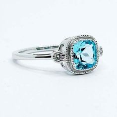 a ring with an aqua blue stone in the center and two diamonds on each side