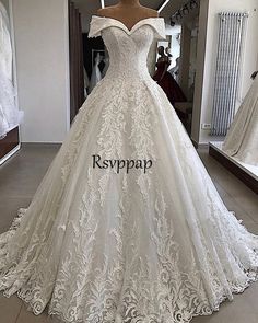 a white wedding dress on display in front of a mirror