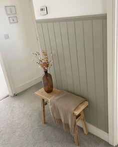 a small wooden bench with a vase on it