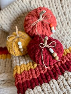 three crocheted pumpkins sitting on top of a blanket