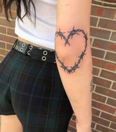 a woman with a heart tattoo on her arm and barbed wire in the shape of a heart