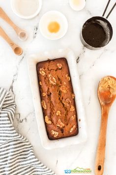 the ingredients to make an oatmeal loaf are laid out on a marble counter top