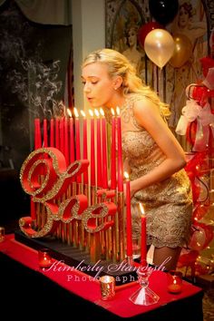 a woman standing in front of a birthday cake with candles