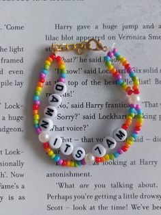 two bracelets with letters on them sitting on top of an open page of a book